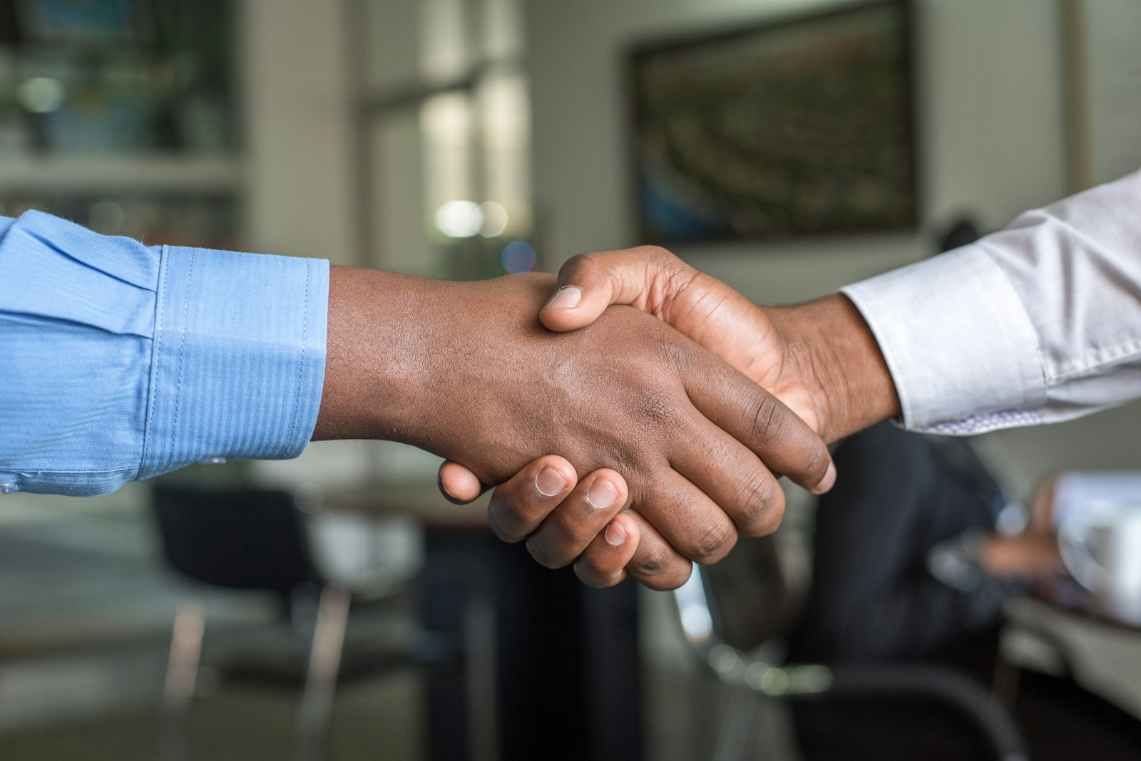 Poignée de main entre un conseiller et son client, symbole d'un engagement de confiance